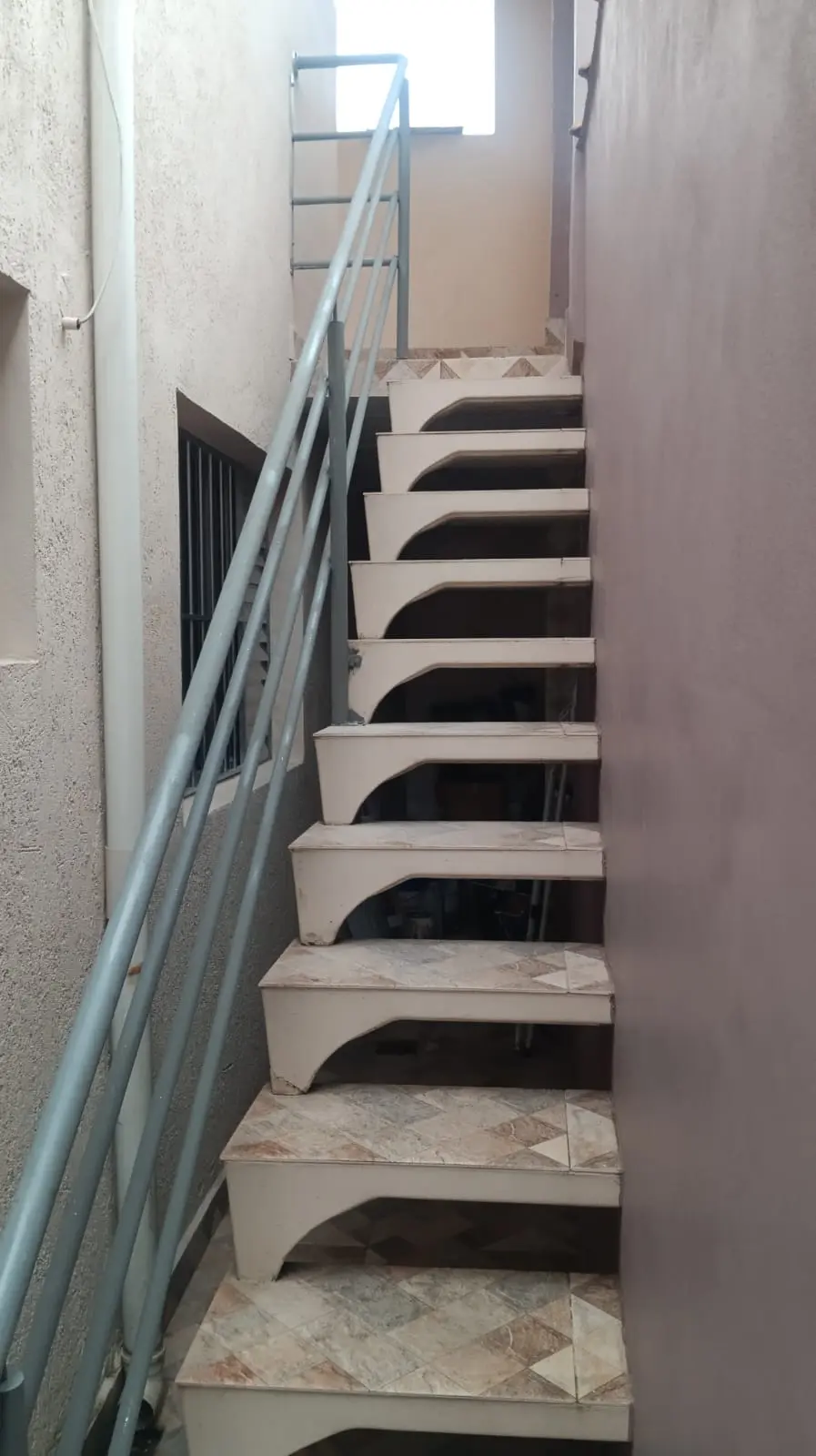 Corrimão metálico acompanhando uma escada